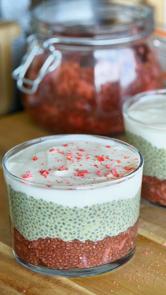 Duo pudding fraise et matcha dans un verre, présenté avec des fraises fraîches et une touche de poudre de matcha
