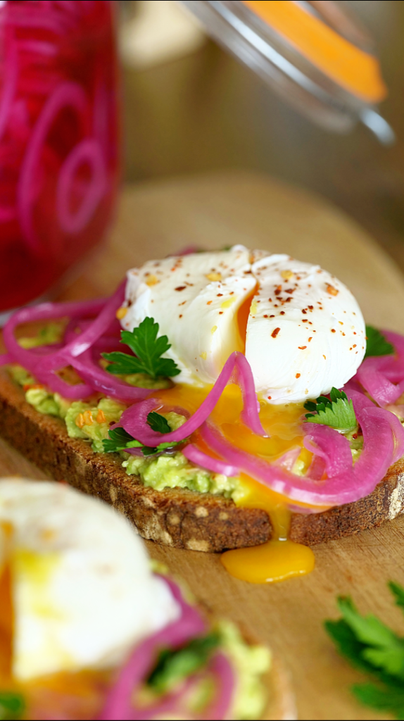 Pickles d’oignons rouges dans un bocal en verre, marinés et colorés, prêts à déguster