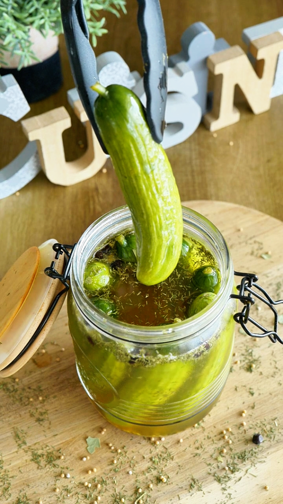 Pickles de concombres croquants en bocal, marinés avec vinaigre, épices et herbes aromatiques