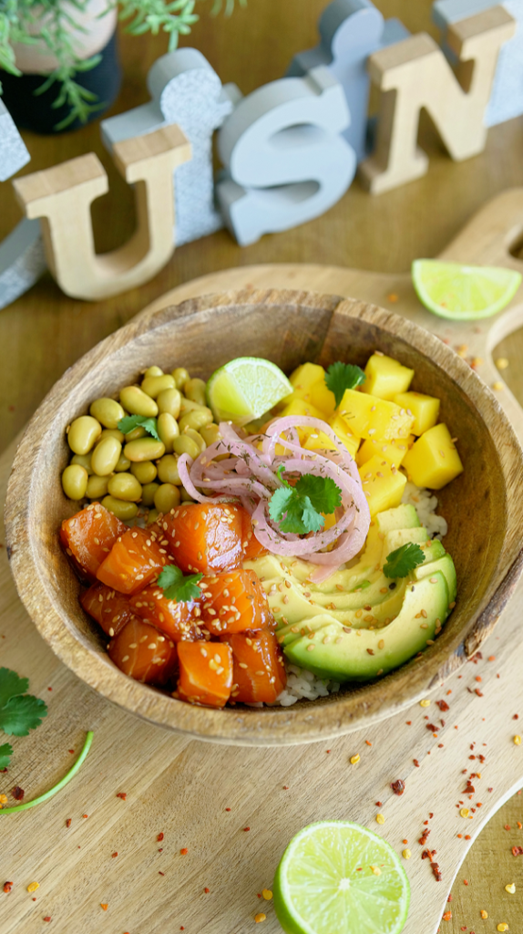 Poké bowl saumon mariné servi dans un bol coloré avec saumon mariné, riz, avocat, légumes frais et garnitures gourmandes pour un repas équilibré et savoureux.