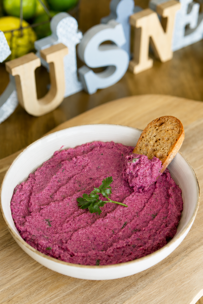 Tartinade betterave et feta servie dans un bol, garnie de feta émiettée et de persil frais, accompagnée de pain grillé.